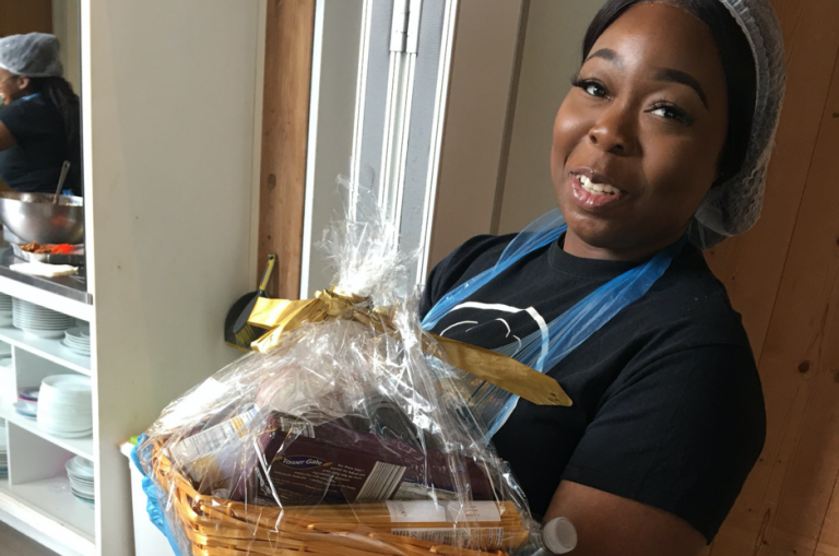 young woman holding hamper of tinned food