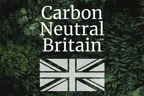 Carbon Neutral logo on background of dark green leaves