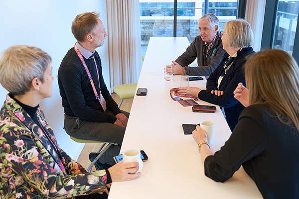 group of 5 adults seated around a table